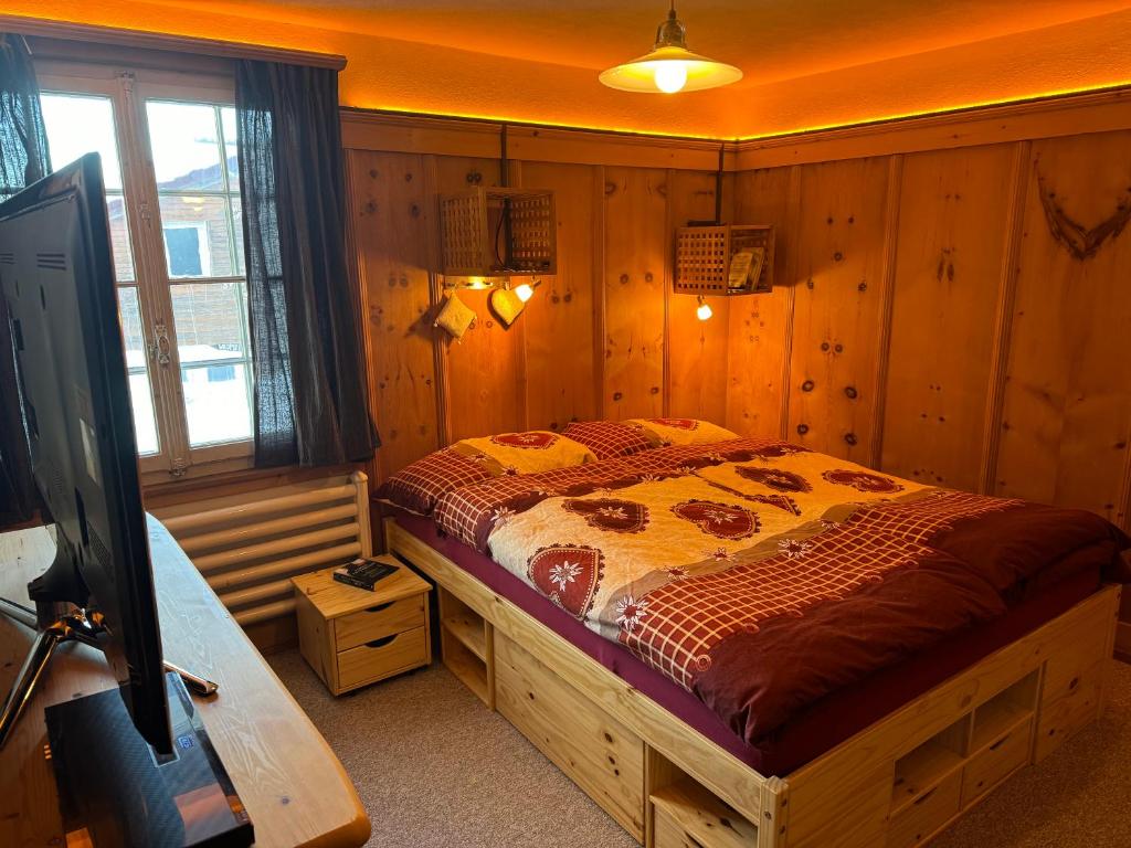 - une chambre avec un lit dans une pièce dotée de murs en bois dans l'établissement Flumserberg, à Flumserberg