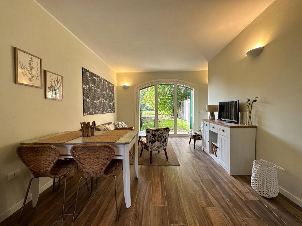 uma sala de jantar com uma mesa e cadeiras e uma televisão em Canovetta Country House "Jakiro" - nearby Cremona 