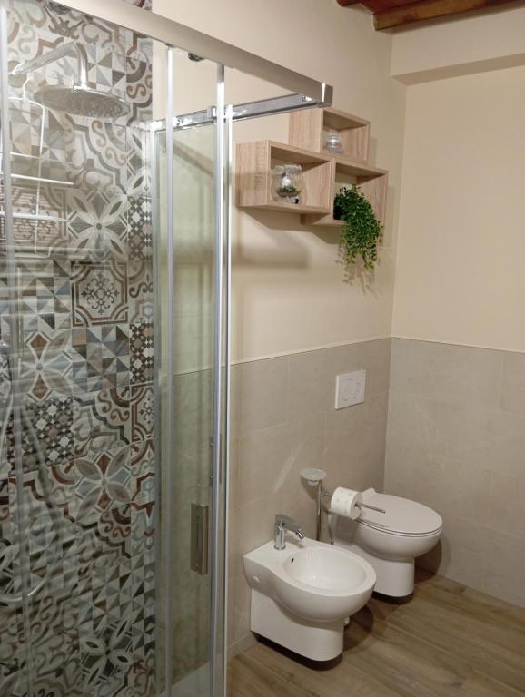 a bathroom with a toilet and a glass shower at Monolocale Lucca PellegriniLittleHouse in Lucca