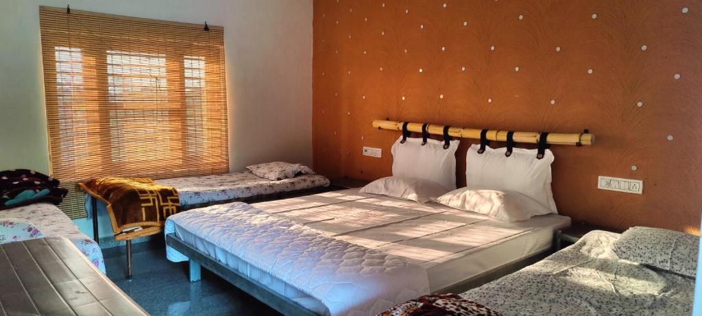 1 dormitorio con 2 camas y ventana en Lalera stay, en Chāndawāri