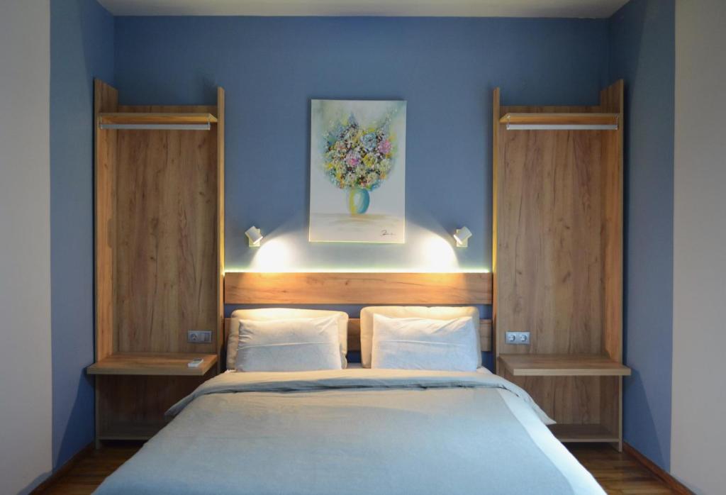 um quarto com uma cama e um quadro na parede em Thess1home Apartments em Tessalónica