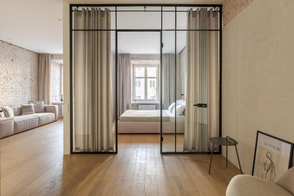 um quarto com uma cama e uma sala de estar com portas de vidro em InshiApartments on Rynok Square em Lviv