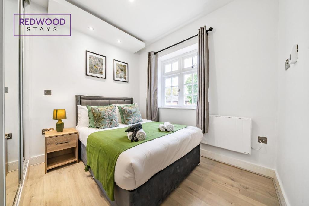 ein Schlafzimmer mit einem Bett mit zwei ausgestopften Tieren darauf in der Unterkunft BRAND NEW, 1 Bed 1 Bath, Modern Town Center Apartment, FREE Parking, Netflix By REDWOOD STAYS in Aldershot