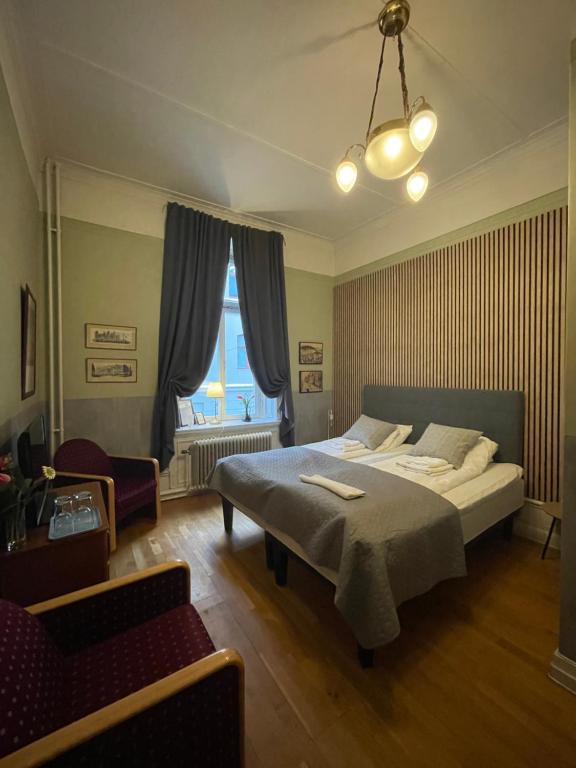 Lilla Hotellet في سوندسفال: غرفة نوم بسرير واريكة وكرسي