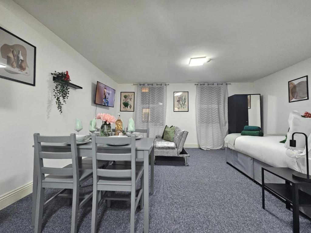 een kamer met een tafel en een bed en een slaapkamer bij LiveStay-Studio Flat in Dalston in Londen