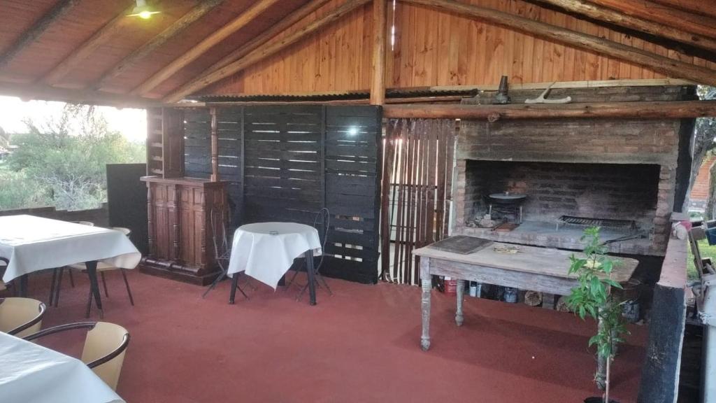 Habitación con chimenea, mesa y sillas. en Dormis El Colibrí en Panaholma