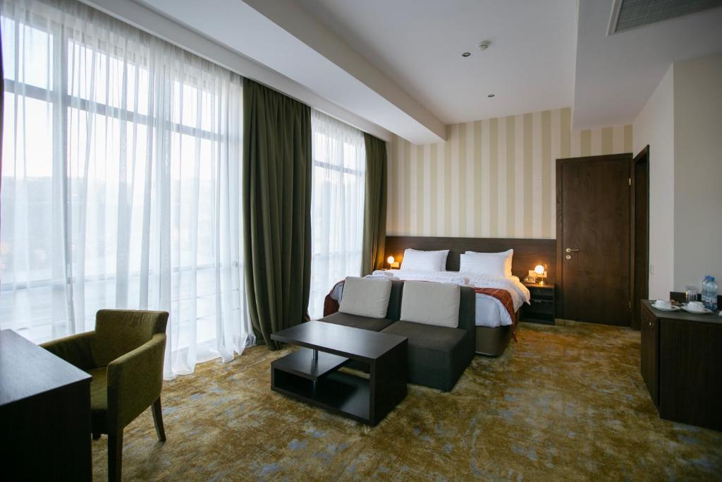 ein Hotelzimmer mit einem Bett und einem Tisch in der Unterkunft Citrus Hotel in Tbilisi City