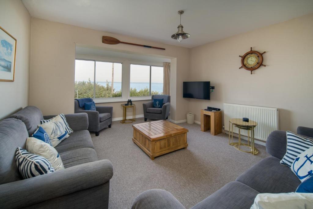 ein Wohnzimmer mit Sofas und einem TV in der Unterkunft Solenta in Yarmouth