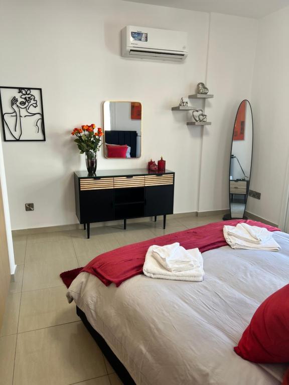 拉納卡的住宿－Oceania bay village Pyla，一间卧室配有一张带梳妆台和镜子的床