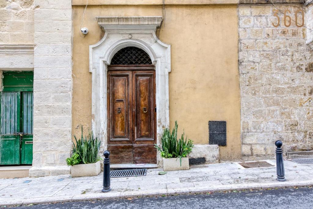 a wooden door on the side of a building at Fully equipped 2BR house of character in Floriana by 360 Estates in Il-Furjana