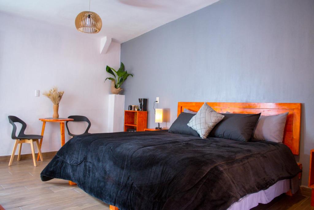 um quarto com uma cama grande e um cobertor preto em Piedra Negra Boutique Hotel em San Cristóbal de Las Casas