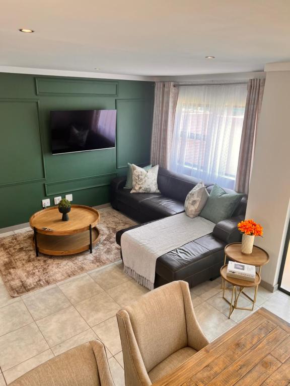 sala de estar con sofá y mesa en Makarios en Pretoria