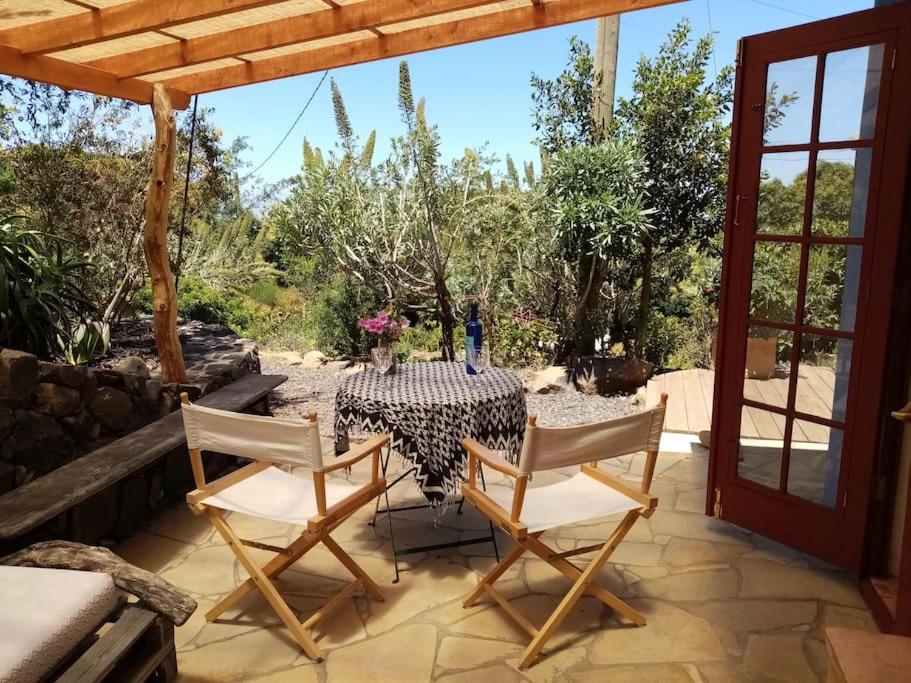 einen Tisch und Stühle auf einer Terrasse mit Aussicht in der Unterkunft Finca Caboquitos in Garafía