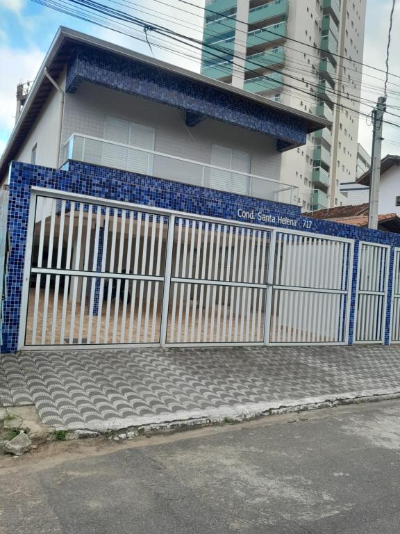 CASA NA PRAIA GRANDE pé na areia في برايا جراندي: بوابة زرقاء وبيضاء امام مبنى