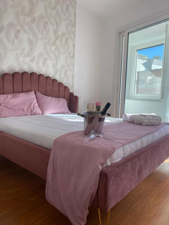 ein Bett mit einer rosa Decke und einem Fenster in der Unterkunft Labanca's Luxury center in Matera