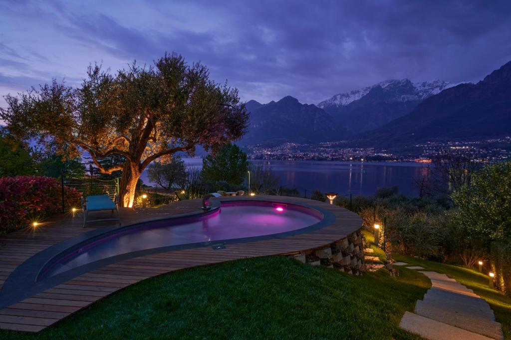 a swimming pool in a backyard with a view of the mountains at Villa Costanza- private heated pool, steam room & sauna - Bellagio Village Residence in Oliveto Lario