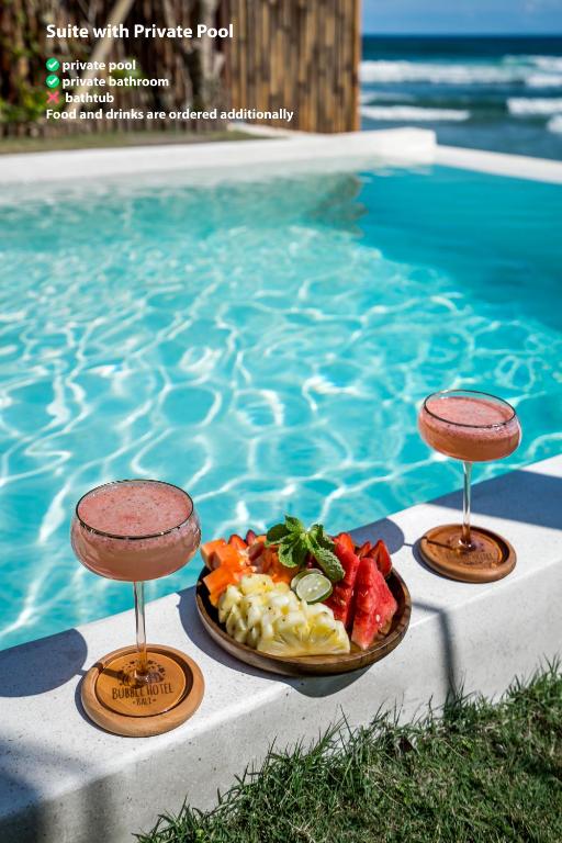un piatto di cibo su un tavolo accanto a una piscina di Bubble Hotel Nyang Nyang - Adults only a Uluwatu