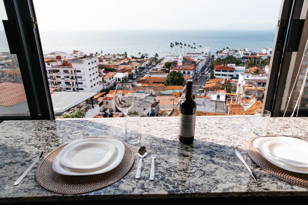 Monyxbnb Hotel في بويرتو فايارتا: طاولة مع زجاجة من النبيذ وطاولة مطلة