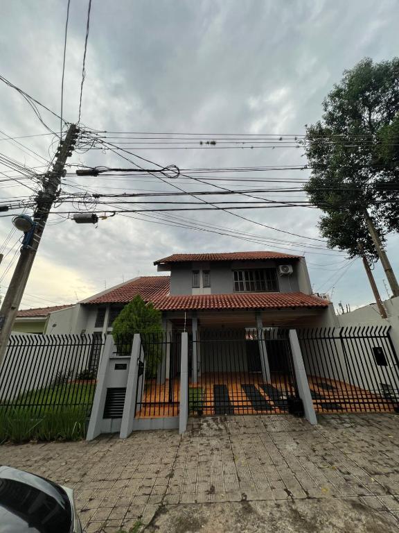 una casa con una valla delante de ella en Pousada cravo & canela en Maringá
