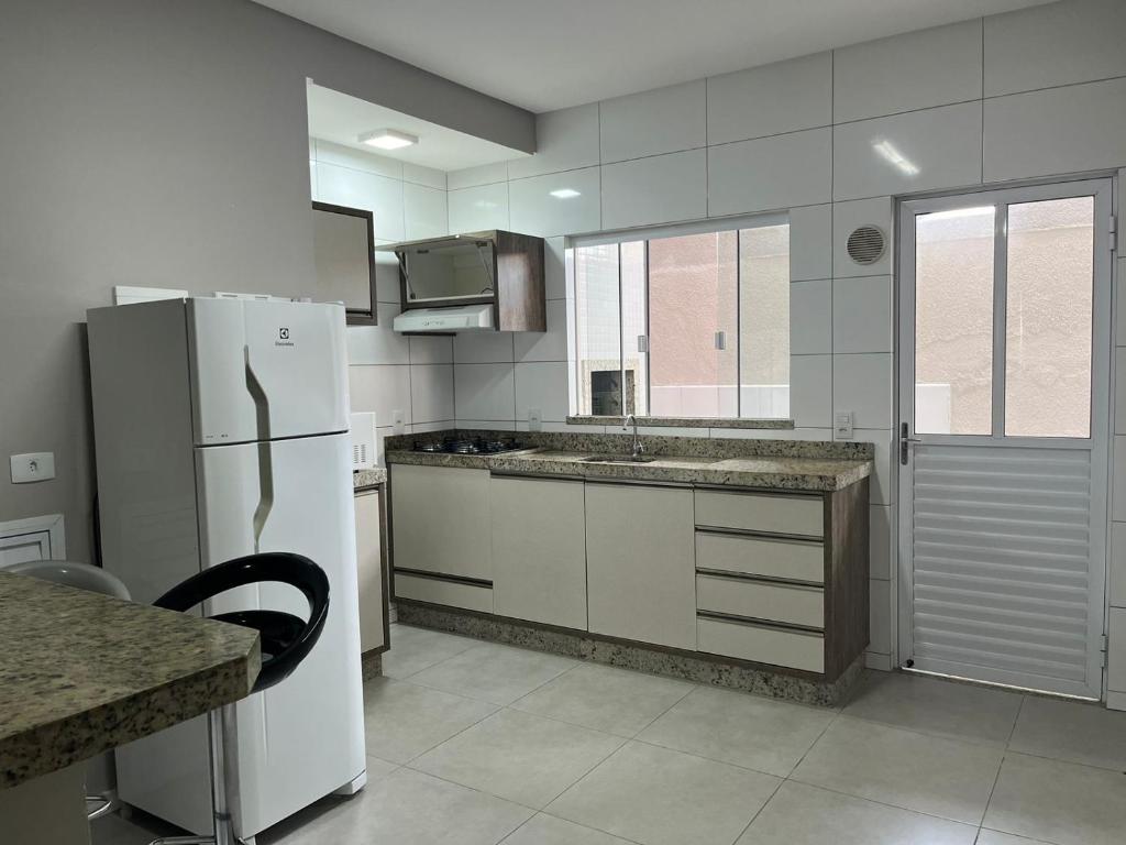 cocina con nevera blanca y fregadero en Apartamento Fátima PARA FAMÍLIA, en Balneário Camboriú