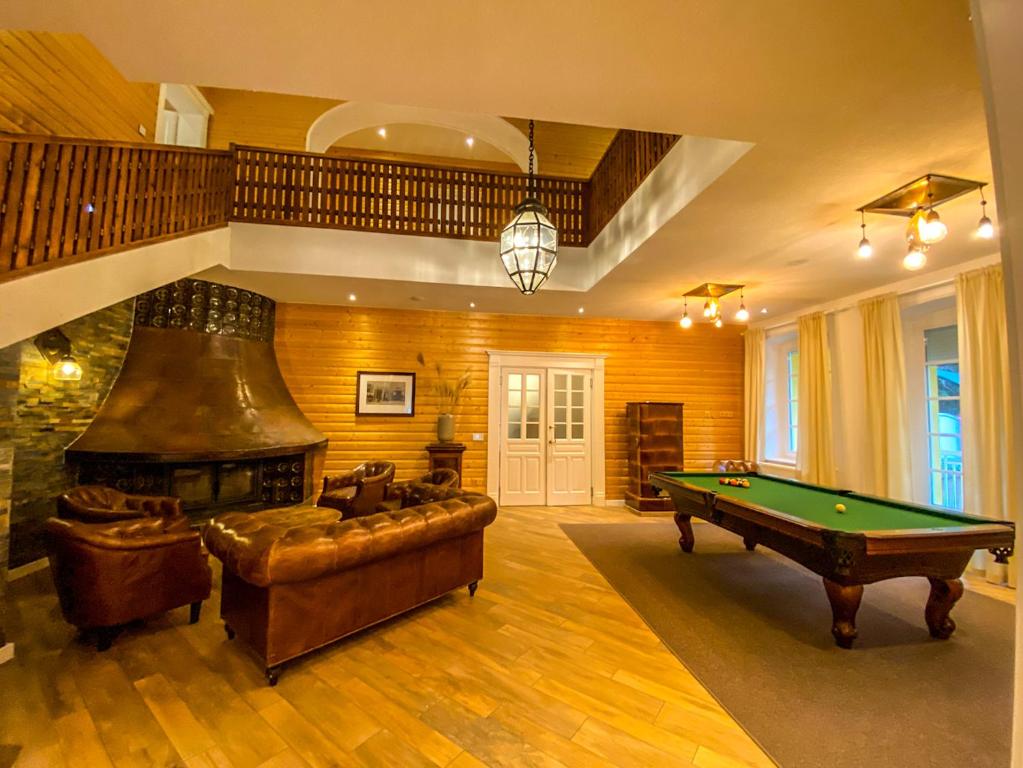 ein Wohnzimmer mit einem Billardtisch und einem Kamin in der Unterkunft Luxusvilla Österreich in Scheibbs