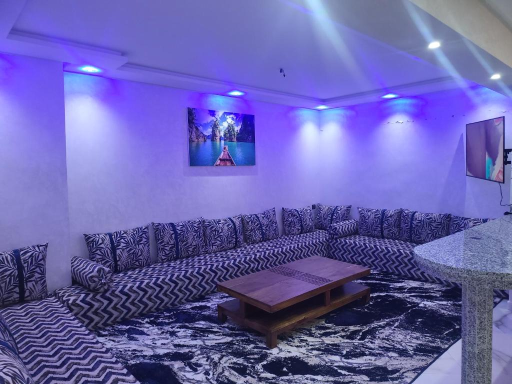 マラケシュにあるMagnifique appartement duplex à 5min de l'aéroport de Marrakechのソファとテーブルのあるリビングルーム