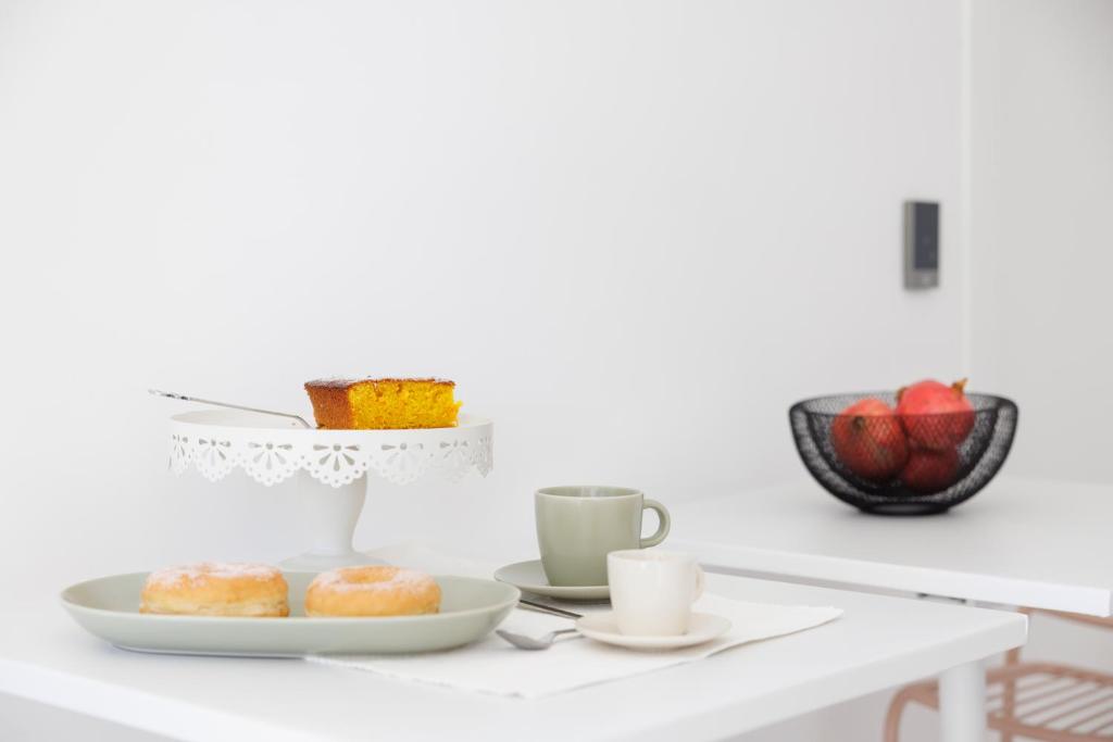 a table with a plate of donuts and cups of coffee at Essentia Rooms & Relax in Vasto