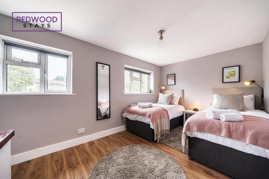 a bedroom with two beds and a window at 2 Bed 1 Bath House, Perfect for Corporate, Contractors & Families x2 FREE Parking, Garden, Netflix By REDWOOD STAYS in Alton