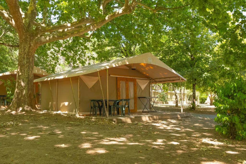 a tent under a tree in a park at Camping la Rouvière in Chame