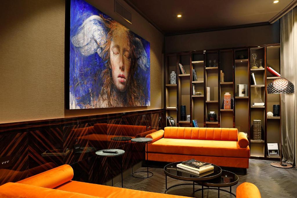 ローマにあるU-Visionary Roma Hotelのリビングルーム(オレンジ色の家具、大きな絵画付)