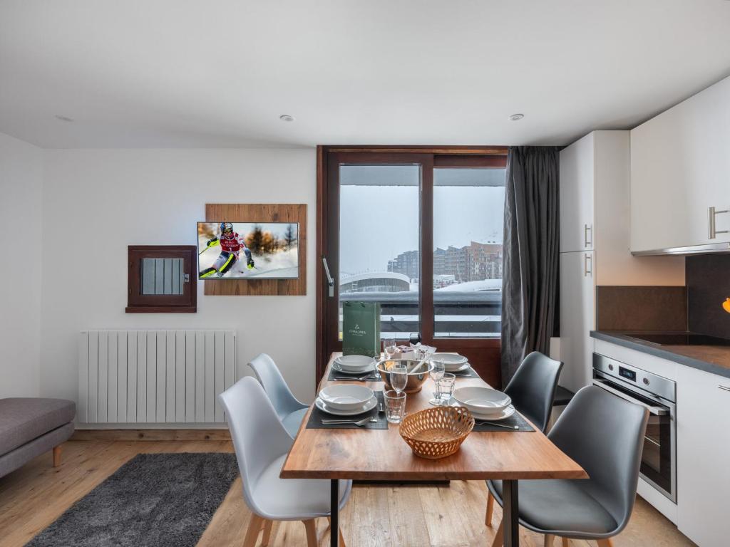 une cuisine et une salle à manger avec une table et des chaises dans l'établissement Appartement rénové, ski aux pieds, cœur de Val Thorens - FR-1-640-34, à Val Thorens