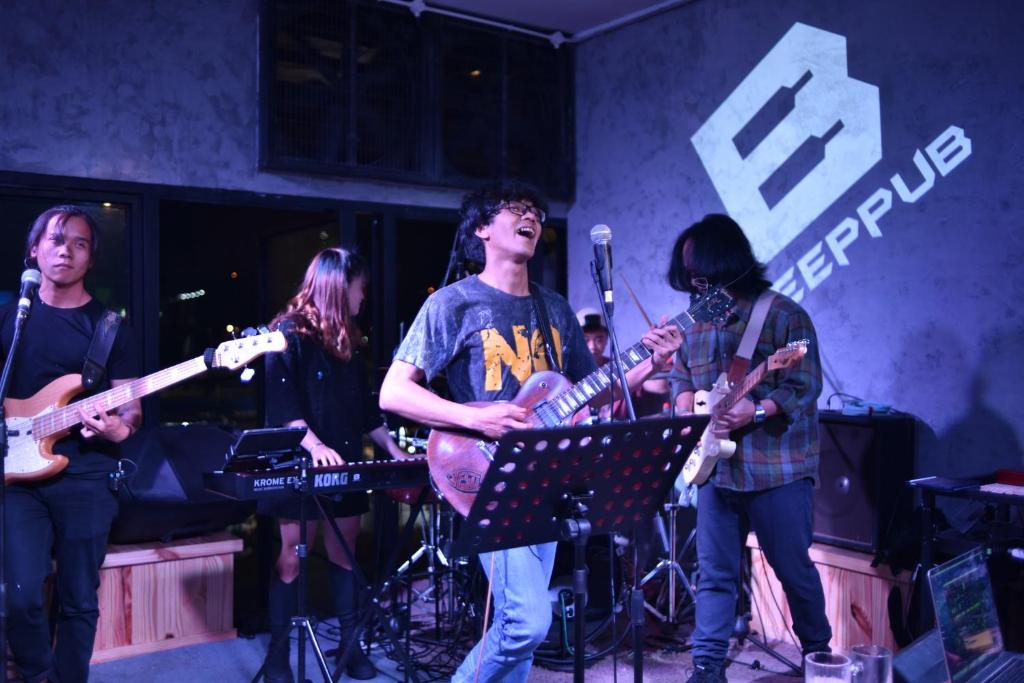 a group of people playing instruments on a stage at Hugo's Family in Da Lat