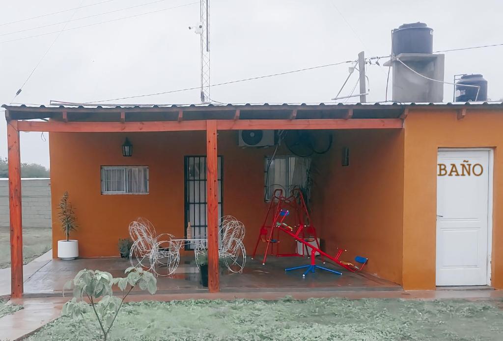 een klein oranje gebouw met een fiets buiten geparkeerd bij Casa de Campo Atenea in Santiago del Estero