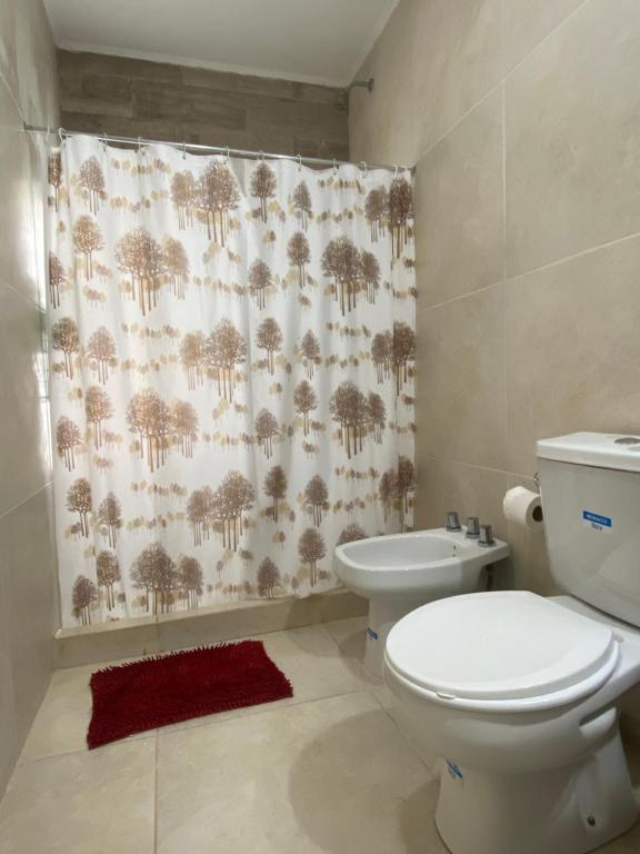 a bathroom with a toilet and a shower curtain at - Casa de campo - in Federación