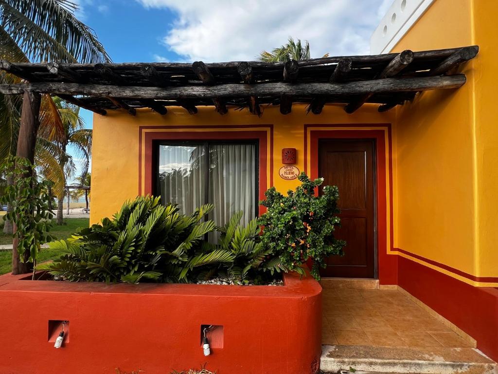 a yellow and orange house with a door at Hotel Manglares in Celestún