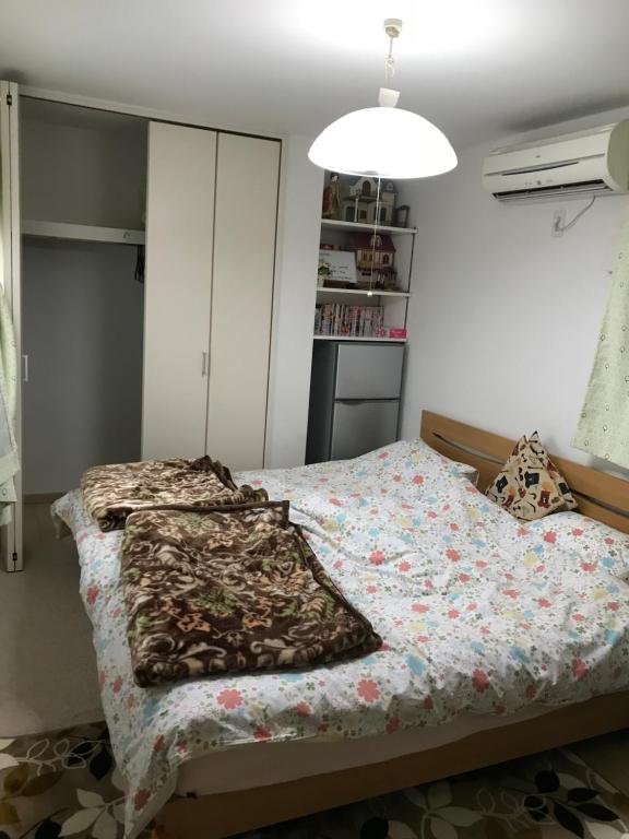 sypialnia z łóżkiem z kołdrą kwiatową w obiekcie Sunny moe oo w Tokio