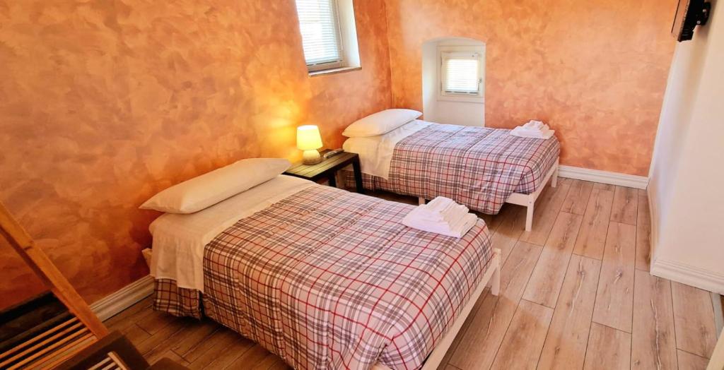 um quarto com duas camas num quarto em La Casetta del Vicolo em Narni