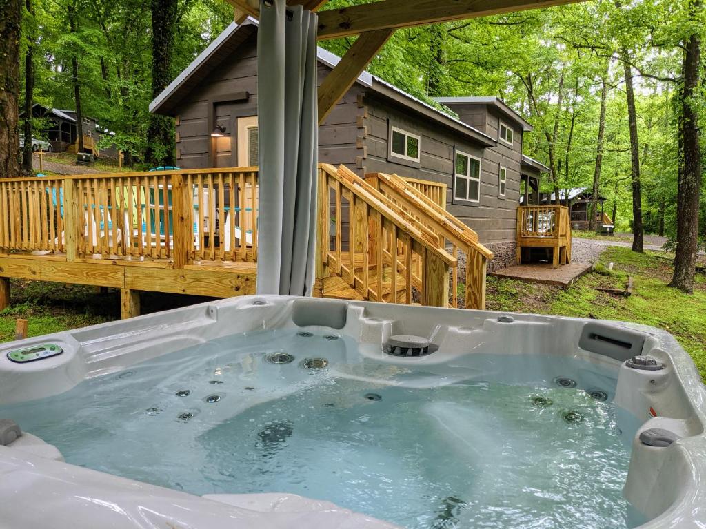 a jacuzzi tub in front of a cabin at Peggers Cabin Luxury Rustic Tiny Cabin Spa in Chattanooga