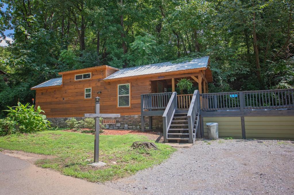 a log cabin with a staircase leading up to it at River Cabin Hot Tub & Swim Spa Near Downtown in Chattanooga