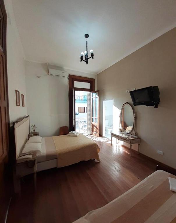 sypialnia z łóżkiem, lustrem i telewizorem w obiekcie HOTEL LOURD MARY w mieście Concepción del Uruguay