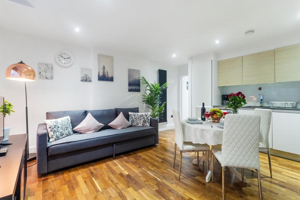 a living room with a couch and a table at Paddington Gardens in London