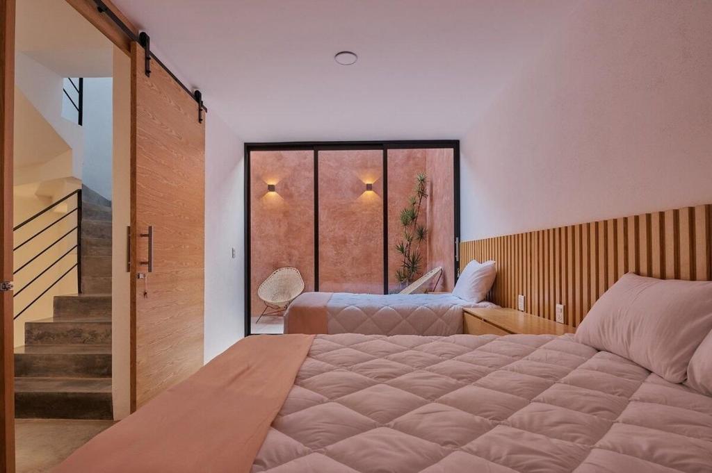 um quarto com uma cama grande e uma janela grande em Hermosa casa ubicada en Oaxaca em Oaxaca City