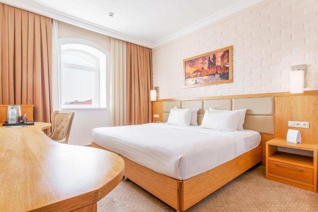 een hotelkamer met een bed en een bureau bij Praga Hotel in Tasjkent