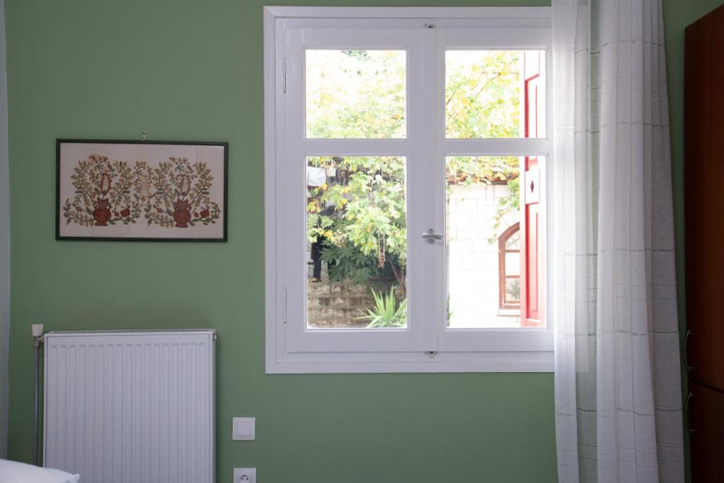 Una ventana blanca en una habitación con radiador en Delphian Colors - Green Edition, en Delfos