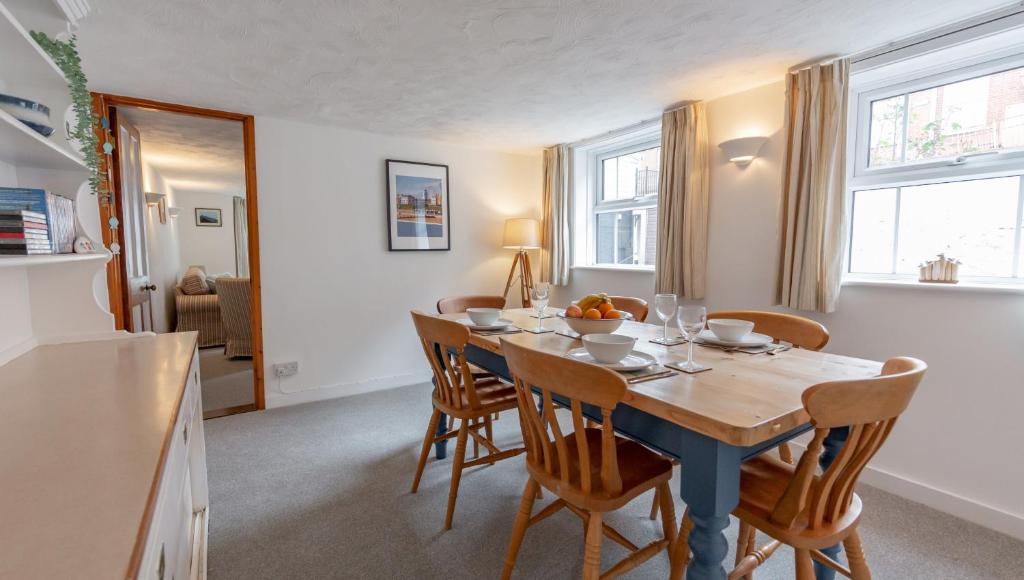 a kitchen and dining room with a table and chairs at Puddle Cottage in Southwold