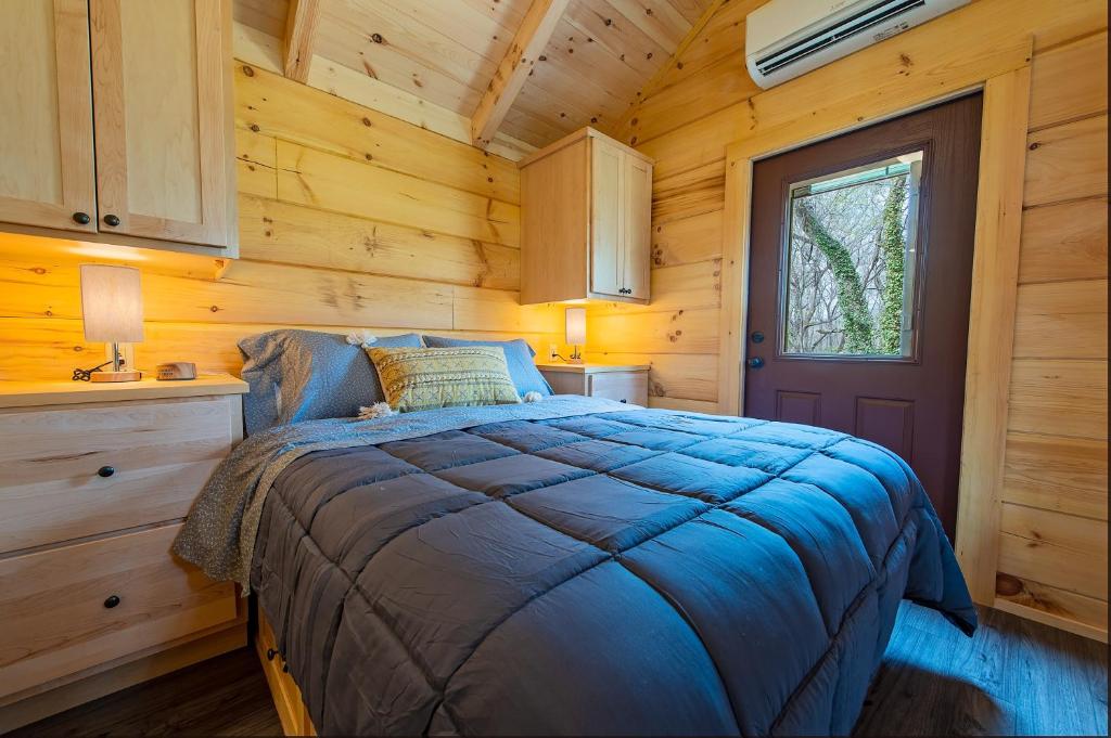 1 dormitorio con 1 cama en una cabaña de madera en Jake Cabin Luxury Hot Tub Cabin Near Downtown en Chattanooga