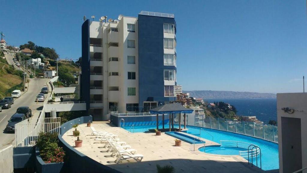 un hotel con piscina y un edificio en Departamento en Reñaca, en Viña del Mar