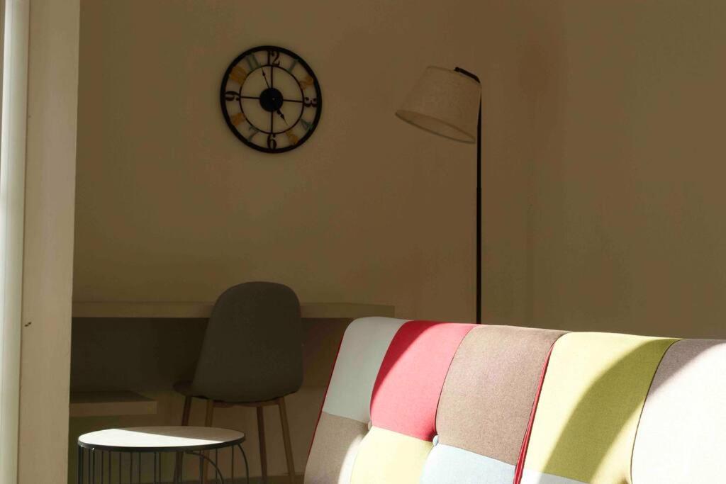 - une chambre avec une horloge sur le mur et une chaise dans l'établissement Appartamento Luna, à Ravenne