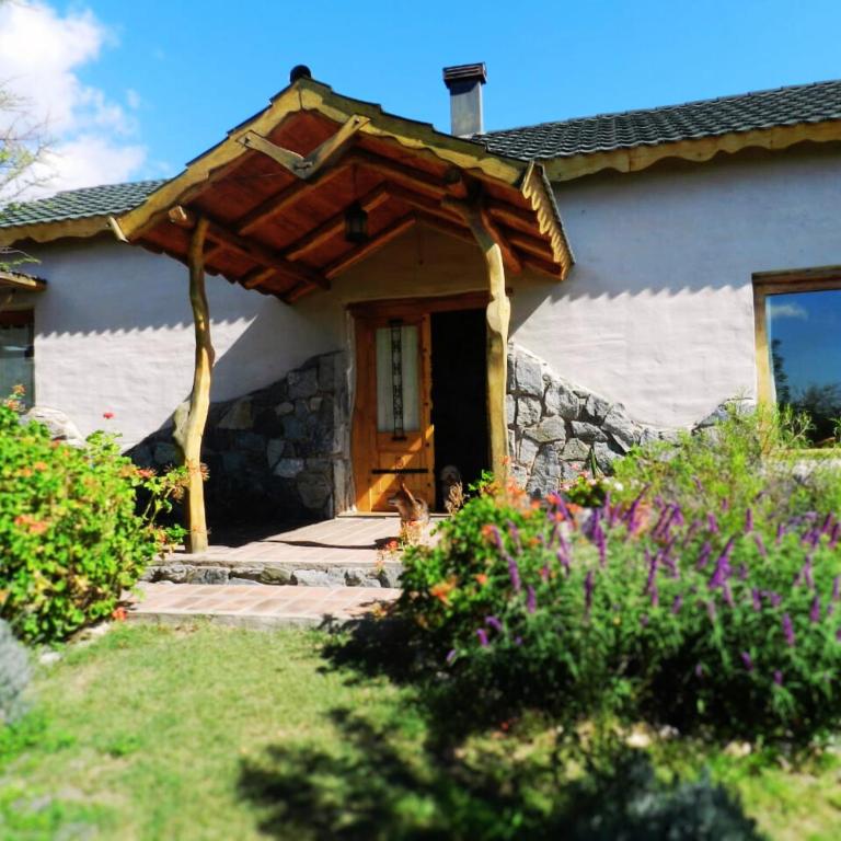 a house with a wooden door and a stone wall at La Calandria in Los Hornillos