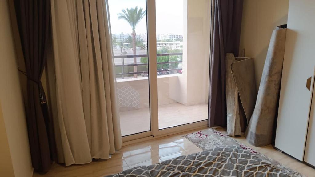 a bedroom with a large glass door to a balcony at Hurghada apartment in Hurghada